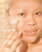 person using a face roller on their cheek