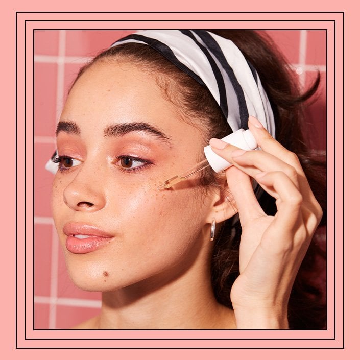 person applying serum to cheekbone