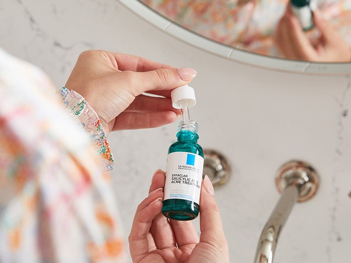 person holding la roche posay bottle