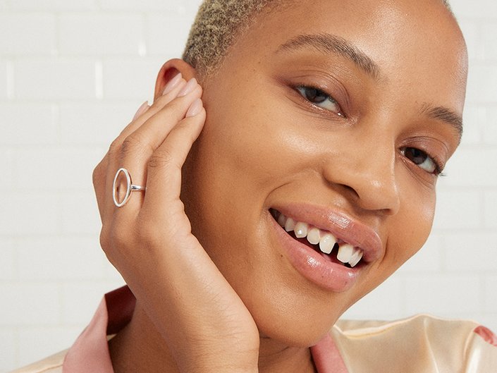 Model smiling and resting their chin in their hand