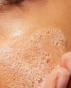 Person with facial cleanser on skin