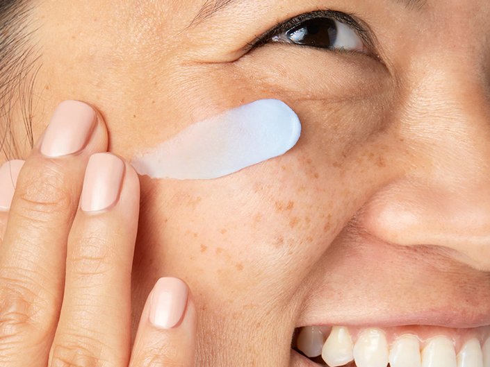 A person applying a cream to their face