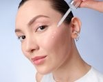 Image of woman applying serum to face