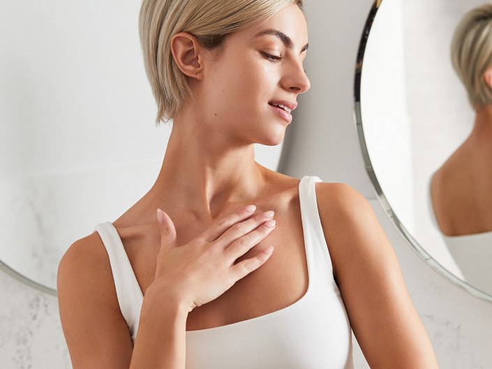 Person turning to the side while touching their collarbone